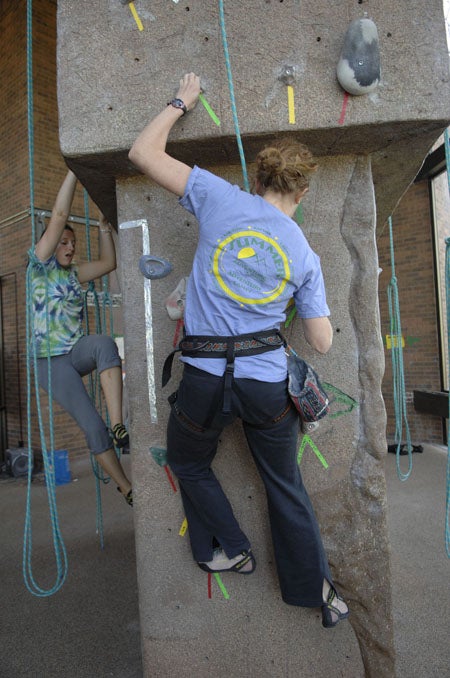 Climber strapped in and climbing on rock wall